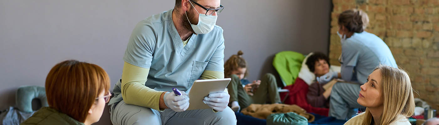 Healthcare worker talking to a refugee.