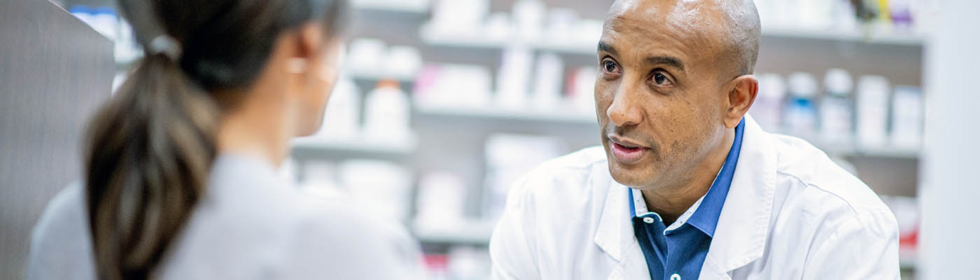 A pharmacist advising a customer about medication.