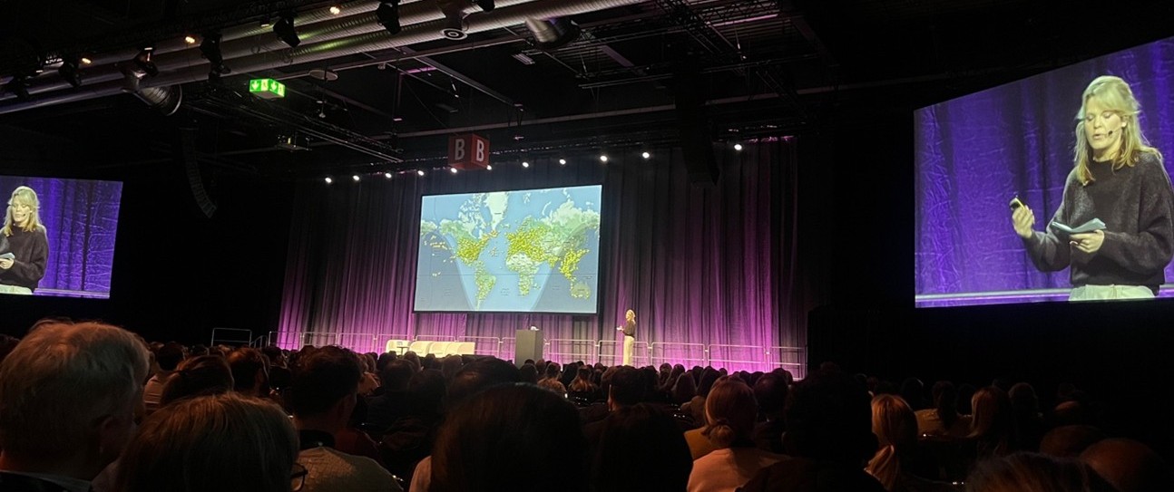 James Tawse – International Forum on Quality and Safety in Healthcare_NIHR GM PSRC The image shows a large and packed conference room. People are sit down and a female speaker is on stage